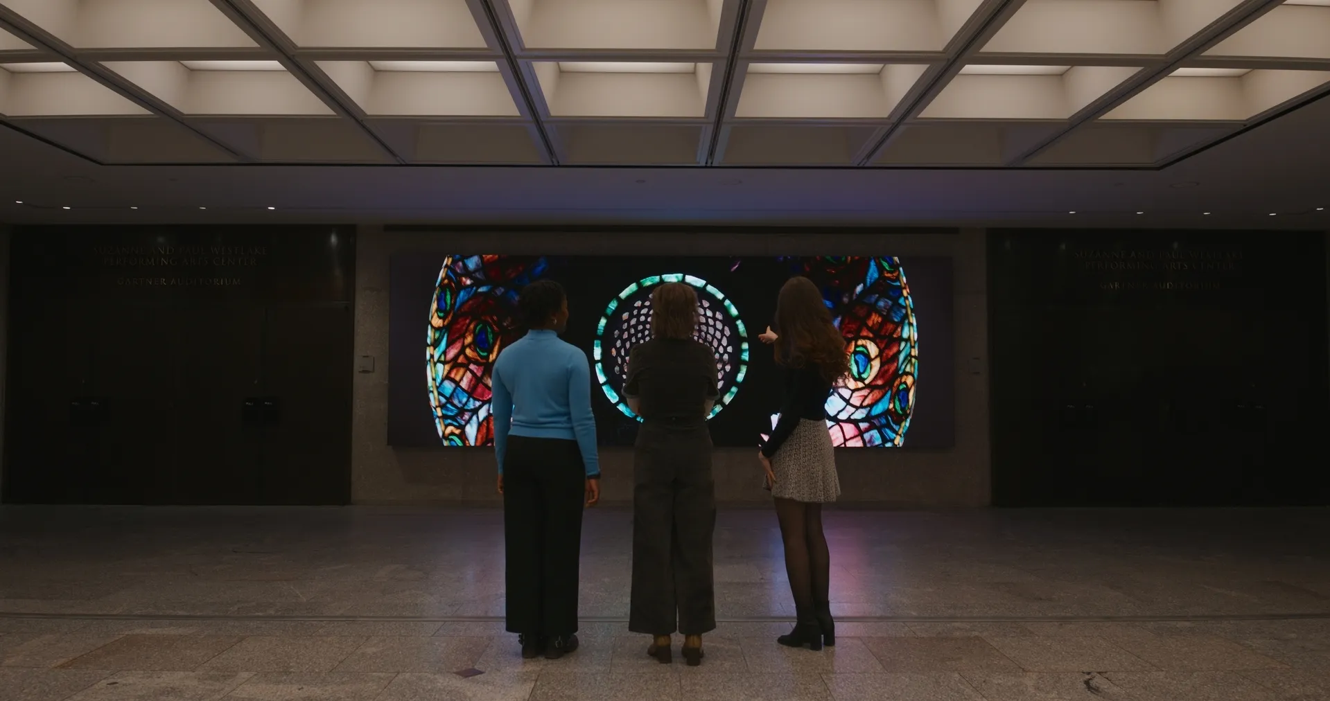 3 people standing in front of the LED wall.